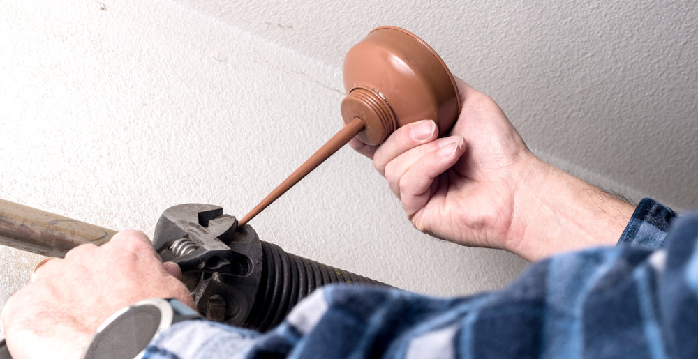What parts of a garage door should I lubricate?